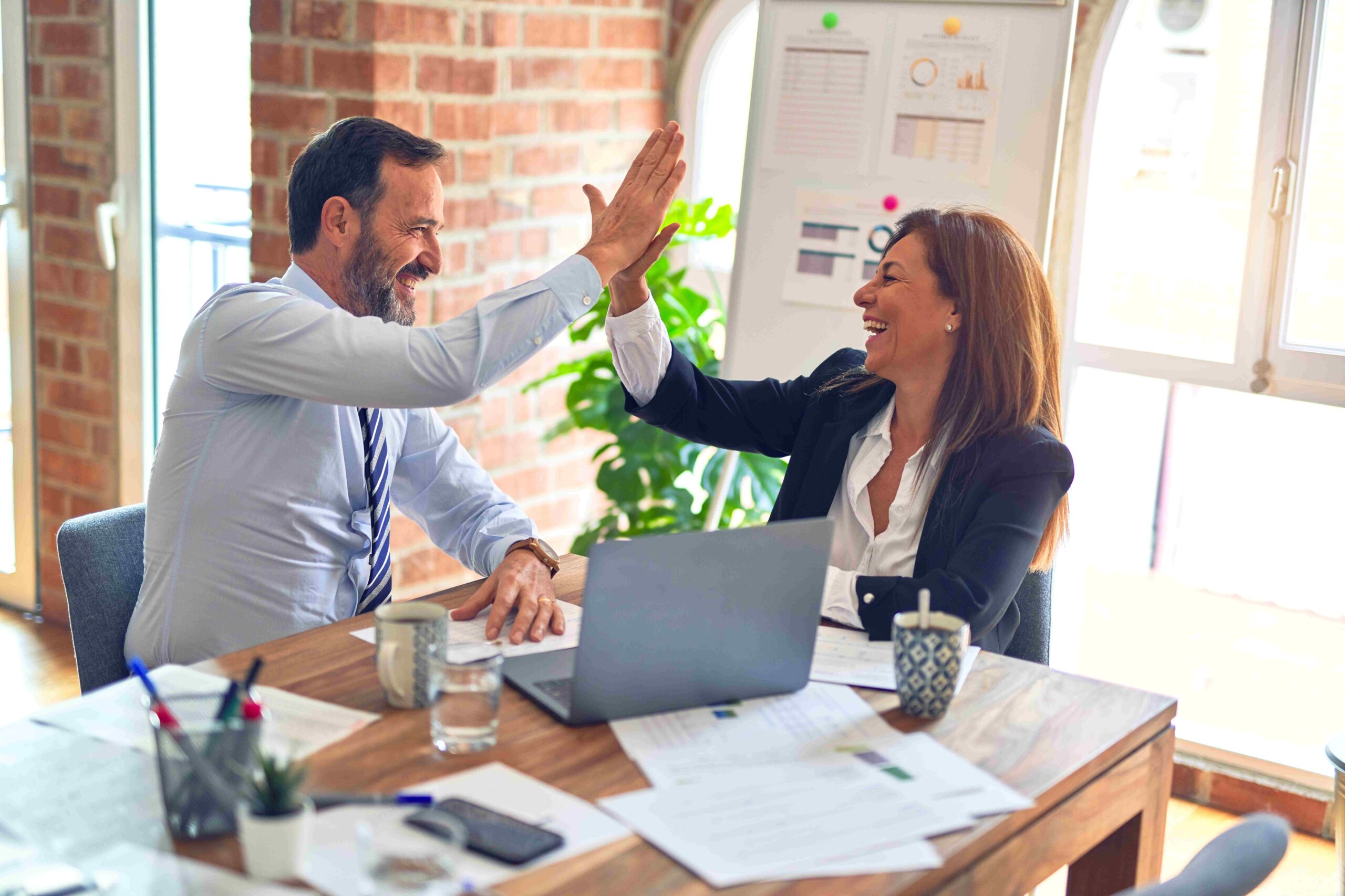 Marketing professionals high fiving and smiling