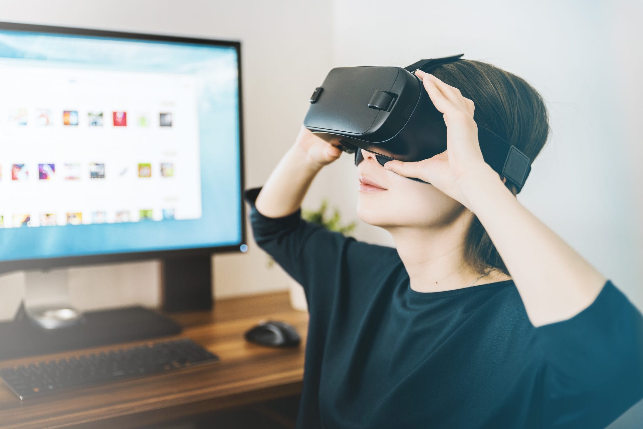 Woman using VR headset at desk